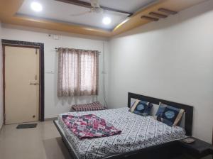 a bedroom with a bed and a window and a door at Shiv- Vatsalya Homestay in Nashik