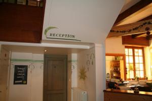 a kitchen with a restaurant sign above a door at Auberge du Lac in Xonrupt-Longemer