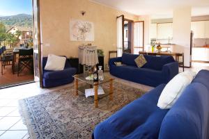 a living room with blue couches and a table at Sunflower - Lake Maggiore Duplex w/ Terrace and Shared Pool in Lesa