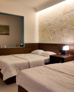 a hotel room with two beds and a painting on the wall at Mik Stay 2 in Danang