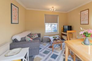 a living room with a couch and a table at Sheriff's Tower Cottage - West in Bishop Auckland