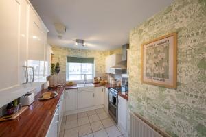 a kitchen with white cabinets and a picture on the wall at Sheriff's Tower Cottage - West in Bishop Auckland