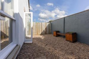 a patio with a window and a bench next to a building at Sheriff's Tower Cottage - West in Bishop Auckland