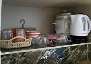 a shelf with glass bowls and a coffee maker at Negradas Transient Inn-with Air-conditioning in Manolo Fortich