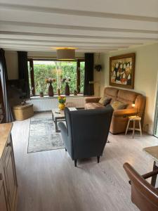 a living room with a couch and a table at Chalet Wild Forest, knus chalet op de Veluwe met gratis parkeren in Putten
