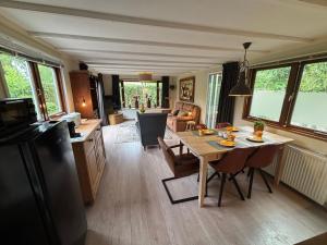 a kitchen and living room with a table and a dining room at Chalet Wild Forest, knus chalet op de Veluwe met gratis parkeren in Putten +19 photos