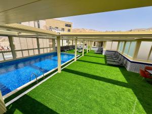 a balcony with a swimming pool and green grass at Petra Moon Hotel in Wadi Musa
