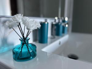a blue vase with white flowers in it on a counter at Infinity Blue in Cefalù
