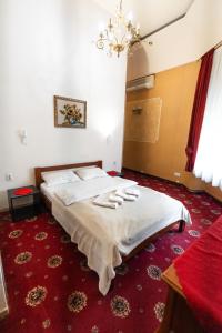 a bedroom with a bed with white sheets and a chandelier at Mini-hotel Franko Park in Lviv +30 photos