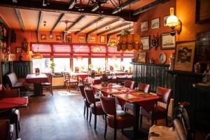 a restaurant with tables and chairs in a room at Stadshotel Jacob Cats in Brouwershaven