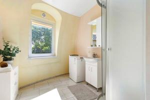 a bathroom with a sink and a washing machine at Kupolo patyrimas in Jurgeliškė