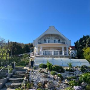 a large white house with a porch and stairs at Herczeg Villa in Balatongyörök