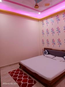 a bedroom with a bed with a pink lighting at Kedarnath villa in Kakarmatha +21 photos