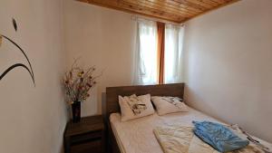a bedroom with a bed with a vase of flowers on it at Cheia House in Cheia