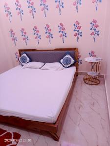 a bed in a room with flowers on the wall at Kedarnath villa in Kakarmatha