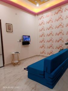 a living room with a blue couch in front of a wall at Kedarnath villa in Kakarmatha