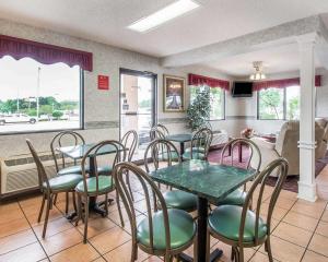 a dining room with tables and chairs and a kitchen at Econo Lodge Dothan West in Dothan