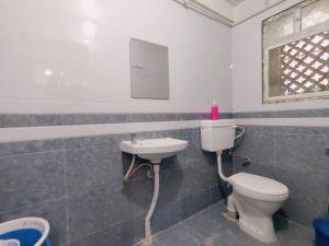a bathroom with a toilet and a sink at Narayan Guest House in Pune