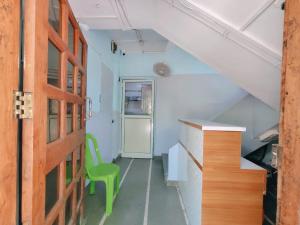 an empty room with a green chair and stairs at Narayan Guest House in Pune
