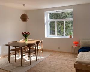 a dining room with a table and chairs and a window at Cozy Scandinavian design apartment in Bergen