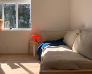 a bed in a room with a red lamp next to a window at Cozy Scandinavian design apartment in Bergen
