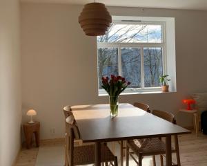 a dining room table with a vase of flowers on it at Cozy Scandinavian design apartment in Bergen +10 photos