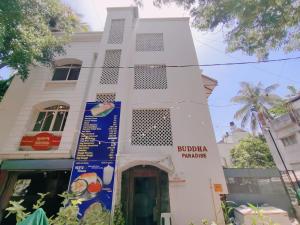 a white building with a sign in front of it at Narayan Guest House in Pune