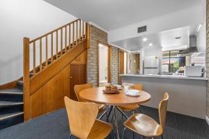 a kitchen and dining room with a wooden table and chairs at Comfort Inn & Suites Sombrero in Adelaide