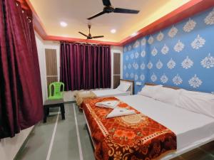 a bedroom with a bed and a ceiling fan at Narayan Guest House in Pune