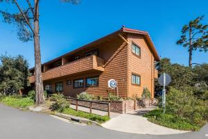 a large wooden house with a sign in front of it at Clarion Collection Carmel Oaks Inn in Carmel