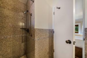 a bathroom with a walk in shower next to a door at Clarion Collection Carmel Oaks Inn in Carmel +28 photos