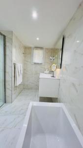 a white bathroom with a tub and a sink at Hotel La Calanque in Cavalaire-sur-Mer +26 photos