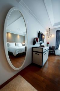 a bedroom with a large round mirror and a bed at De Paviljoen Bandung in Bandung