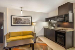 a living room with a yellow chair and a kitchen at Quality Hotel in Burlington