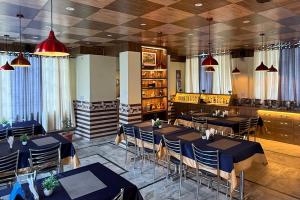 a restaurant with tables and chairs in a room at Hotel Buro The Gate in Kalpa