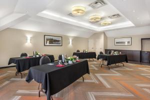 a conference room with tables with black table cloths at Quality Hotel in Burlington +111 photos