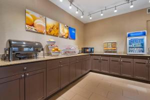 a kitchen with brown cabinets and a coffee shop at Comfort Suites Highlands Ranch Denver Tech Center Area in Highlands Ranch
