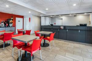 a restaurant with red chairs and tables and a kitchen at Econo Lodge - Conyers in Conyers +39 photos