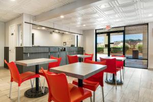 a dining room with red chairs and a table at Econo Lodge - Conyers in Conyers