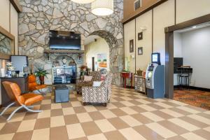 a lobby with chairs and a stone wall at Quality Suites Hickory South in Hickory