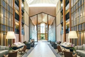 a lobby of a building with couches and chairs at DoubleTree by Hilton Phuket Banthai Resort in Patong Beach