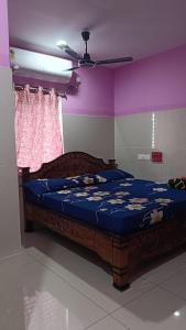 Ein Schlafzimmer mit einem Bett mit blauer Bettwäsche und lila Wänden in der Unterkunft SVS Grands in Ālamūru
