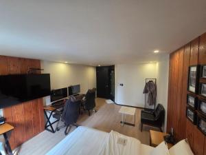 a room with a desk and chairs and a tv at Mc9Hotel in Uijeongbu