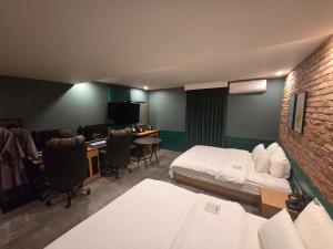 a room with a bed and a desk with a computer at Mc9Hotel in Uijeongbu