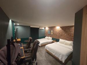 a hotel room with two beds and a chair at Mc9Hotel in Uijeongbu +9 photos