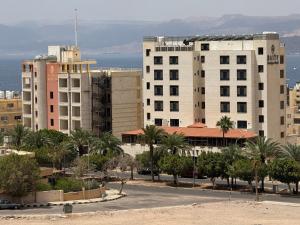 a view of a city with palm trees and buildings at شقق الخامسه الفاخرة Al Amer Luxury Apartments in Aqaba