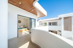 a modern house with white walls and a wooden ceiling at Cassandra Villas - Tropical Private Pool Escape near Beach in Sanur +273 photos