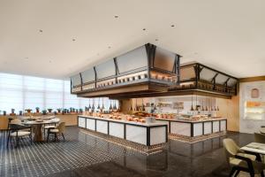 a large kitchen with tables and chairs in a restaurant at Canton Hotel Guangzhou, Tapestry Collection By Hilton in Guangzhou +68 photos