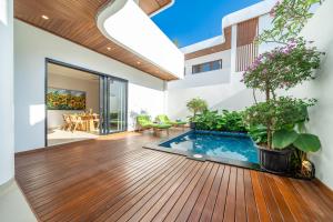 a living room with a swimming pool on a wooden deck at Cassandra Villas - Tropical Private Pool Escape near Beach in Sanur
