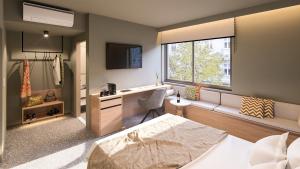 a bedroom with a bed and a desk and a window at Nixon Downtown, a member of Nixon Hotels in Athens